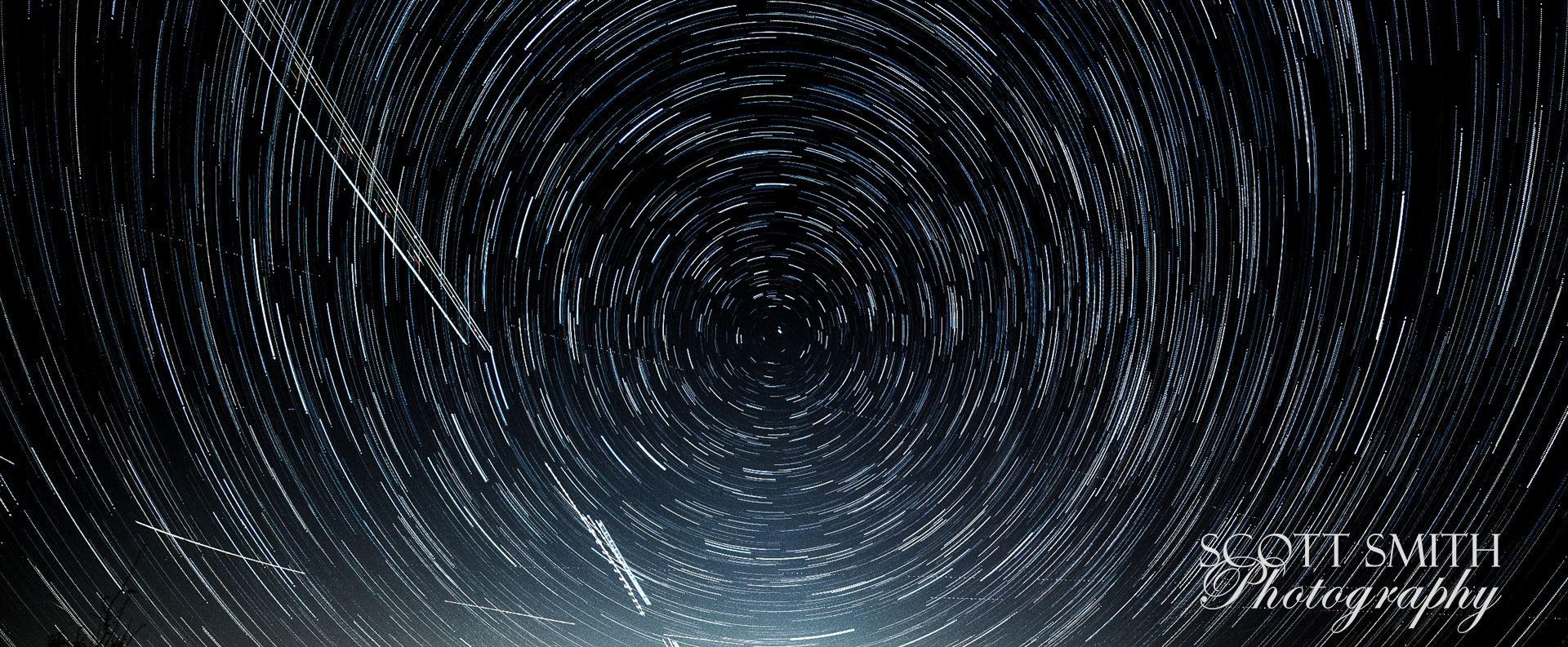 Star Trails - My first attempt at shooting the Aurora Borealis, which turned out to not quite extend down to Denver tonight, turned into my first attempt at merging 103 stacked images into star trails.  The shot is cropped to remove the neighbor's house behind mine. by Scott Smith Photos