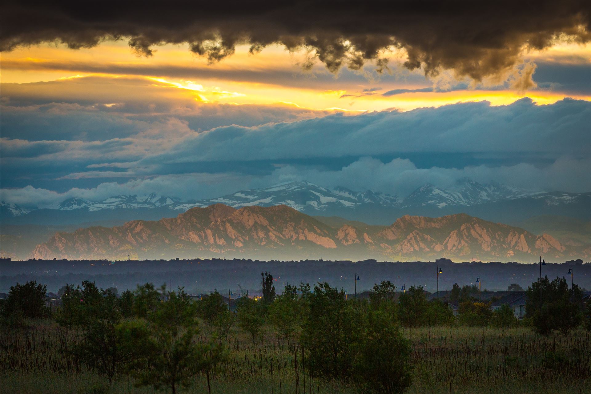 Relected Light on the Flatirons - Interesting weather phenomenon as light from the setting sun reflects on a low cloud layer onto the Flatirons in Boulder, Colorado. Taken from Commerce City, Colorado. by Scott Smith Photos