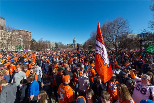 Fans of the Denver Broncos completely fill Civic Park in Denver Colorado. The state capitol building is visible in the center of the frame.