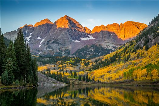 The rising sun lights the peaks of the Maroon Bells.