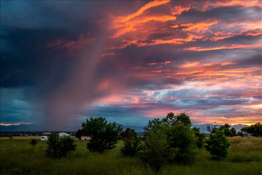 A storm rolls in just as the sun sets, highlighting the clouds with beautiful colors.